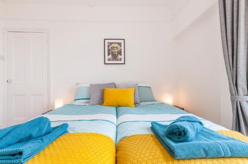 sypialnia z łóżkiem z niebieskimi i żółtymi kocami w obiekcie Chestnut House Exeter w mieście Exeter