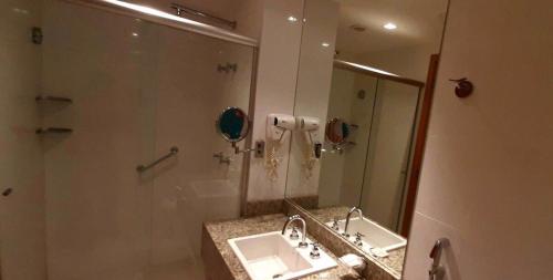 y baño con lavabo y espejo. en Brisas do Lago - Apartamento 2, en Brasilia