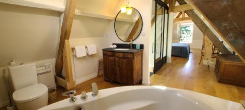 a bathroom with a large white tub and a mirror at Le Bois Flotté - Maison au cœur de la Loire entre ville et nature in Saumur