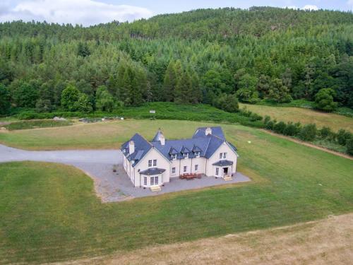 an aerial view of a large white house in a field at Beallach Lodge in Culrain