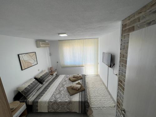 - une petite chambre avec un lit et une fenêtre dans l'établissement Апартамент Панорама Рози, à Sandanski
