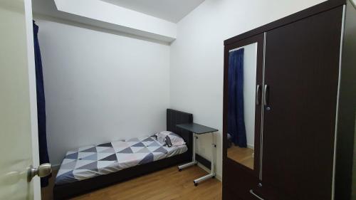 a small bedroom with a bed and a mirror at New Modern Condo with Pool at Bangi in Kampong Tangkas