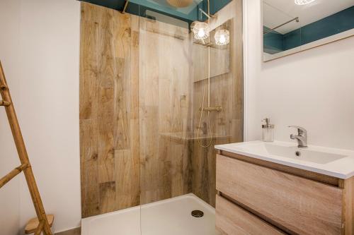 La salle de bains est pourvue d'un lavabo et d'une douche. dans l'établissement LA REV'RIE - vue sur mer avec balcon, à Deauville