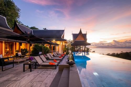 een resort met een zwembad met uitzicht op de oceaan bij Baan Phu Prana Boutique Villa in Surin Beach