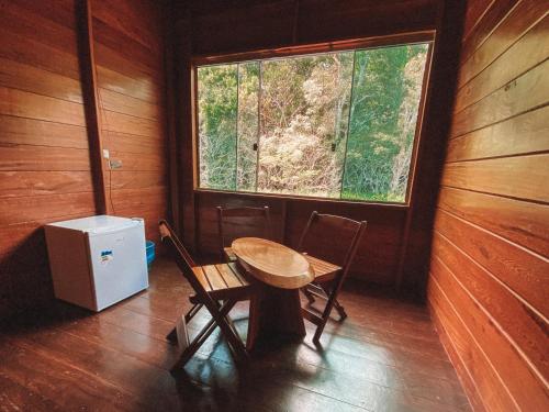 a table and chairs in a room with a window at Amazon Arowana Lodge in Careiro