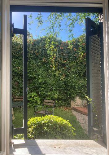 an open door to a garden with a bench outside at Casa Rubinacci in Naples