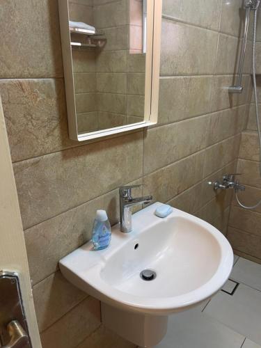 a bathroom with a white sink and a mirror at A Luxury 2 Bedroom With a perfect location in Sweifiyeh in Amman