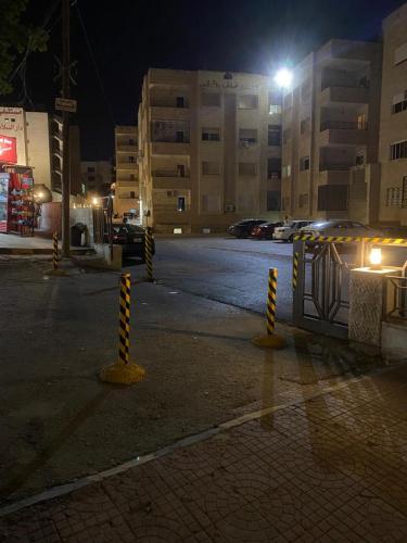 an empty street at night with a parking lot at A Luxury 2 Bedroom With a perfect location in Sweifiyeh in Amman