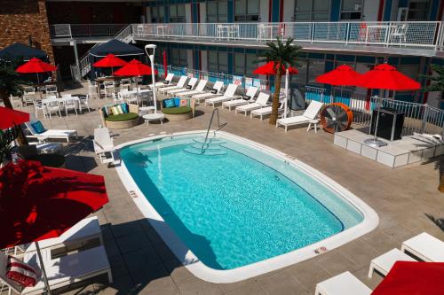 an overhead view of a swimming pool with chairs and umbrellas at Unscripted Durham, Part of JDV by Hyatt in Durham