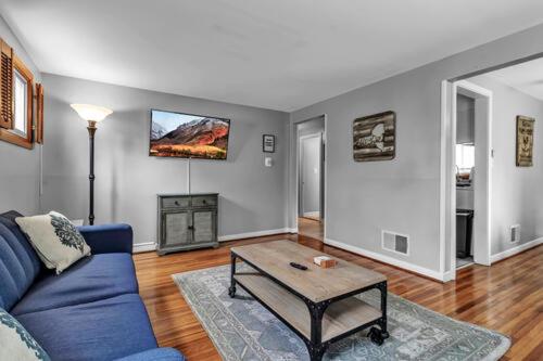 a living room with a blue couch and a table at Gorgeous 2 Queen Bedroom Lower Apartment in North Buffalo with Free Driveway Parking in Buffalo