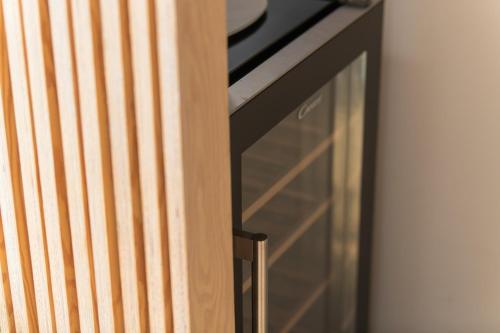 a glass drawer in a wooden cabinet next to a wall at Appartement Guillemins Station Terrace in Liège