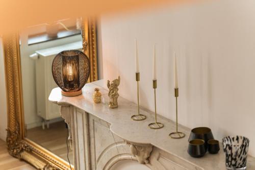 um quarto com uma lareira com velas e um espelho em Appartement Guillemins station em Liège