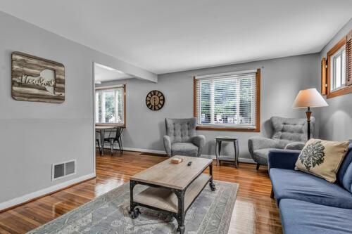 uma sala de estar com um sofá azul e uma mesa em Gorgeous 2 Bedroom Lower Apartment with Free Driveway Parking in North Buffalo em Buffalo