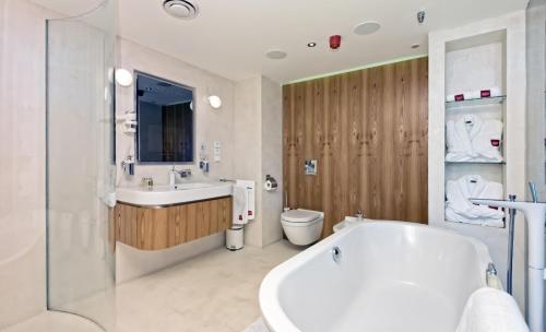 bagno con vasca, lavandino e servizi igienici di SKY SUITE HOTEL a Praga