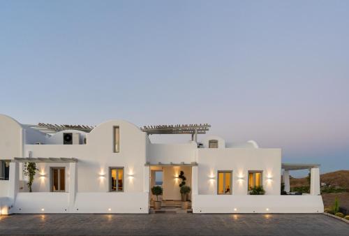 eine weiße Villa mit einer beleuchteten Fassade in der Unterkunft Aegean Diamonds Luxury Suites in Monolithos