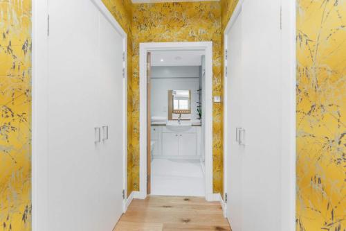 a hallway with yellow walls and a mirror at Glasgow Harbour Clyde Waterfront Apartment in Glasgow