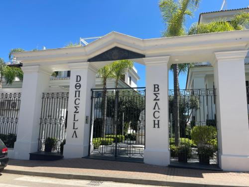 a white building with a gate with the words robinson island at Doncella Beach , apartamento con vistas al mar in Estepona