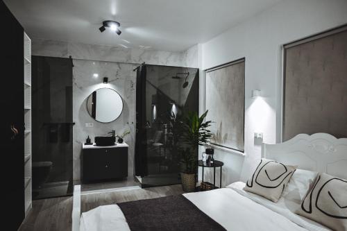 a bedroom with a bed and a shower and a sink at ÁLka - Cozy Room by the Sea With Private Hot Tub in Njarðvík
