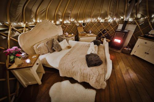 a bedroom with a large bed in a yurt at Secret Cloud House Holidays Luxury Yurts with Hot Tubs in Cauldon