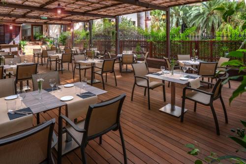 un restaurante con mesas y sillas en una terraza de madera en Hotel SERHS Rivoli Rambla, en Barcelona