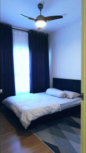a bedroom with a bed with a ceiling fan at New Modern Condo with Pool at Bangi in Kampong Tangkas