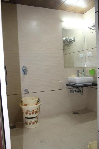 W łazience znajduje się umywalka, toaleta i lustro. w obiekcie Hotel Narayan Palace w mieście Amarsar