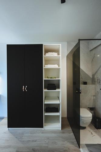a bathroom with a black cabinet and a toilet at ÁLka - Cozy Room by the Sea With Private Hot Tub in Njarðvík