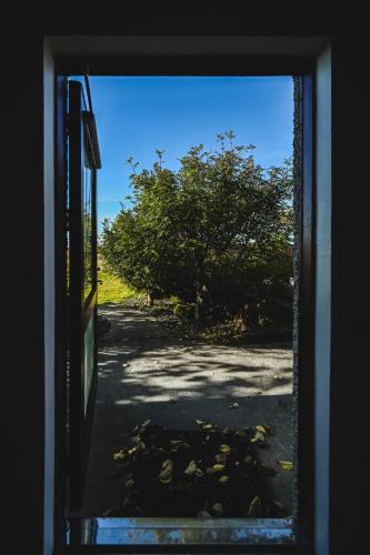 a view from a window of a field through a door at ÁLka - Cozy Room by the Sea With Private Hot Tub in Njarðvík