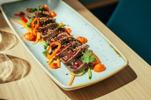 a plate of food with meat and vegetables on a table at Holiday Inn - Bordeaux-Merignac by IHG in Mérignac