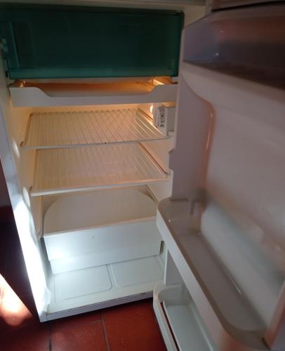 an empty refrigerator with its door open at B&B Badde Cubas in Usini