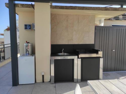 an outdoor kitchen with a sink and a refrigerator at Rooftop condo RAMSES in Antibes