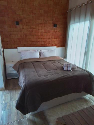 a bedroom with a large bed with slippers on it at Império Cabanas in Urubici