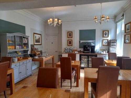 cocina y comedor con mesas y sillas de madera en Fairwater Head, en Axminster