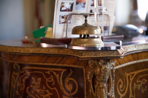 un tavolo in legno con un campanello sopra di Hotel Siros a Verona