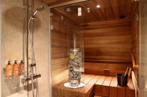 a shower stall with a glass vase on a wooden shelf at Levi Way 1 in Levi