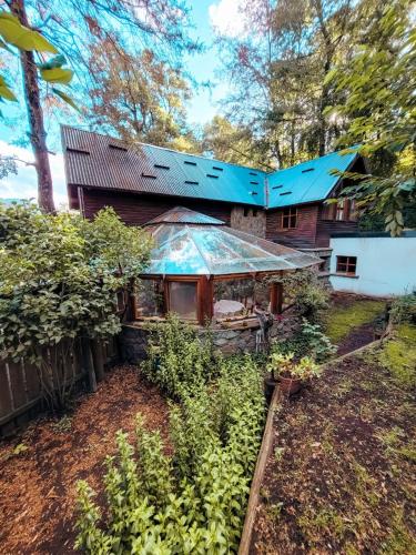 an exterior view of a house with a garden at Cabaña La Tranquila in San Martín de los Andes