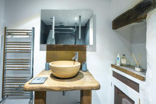 a bathroom with a bowl sink on a wooden counter at St Davids Hideaway with Roll-top Bath & Log Burner in St. Davids