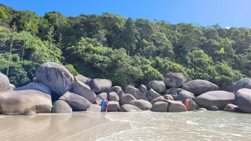 eine Gruppe von Menschen, die auf Felsen im Wasser stehen in der Unterkunft Garden Ville, 200m da Praia de Bombas in Bombinhas