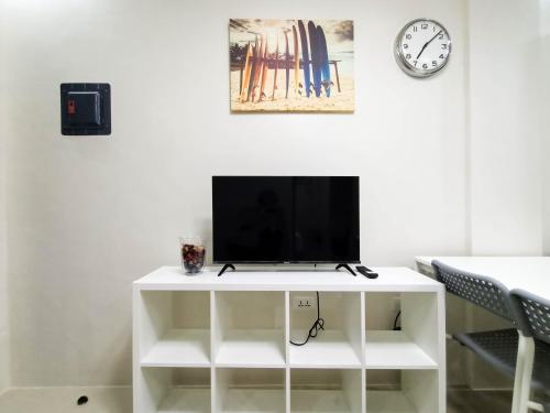 a white entertainment center with a tv on top of it at Manzil Anilao B&B in Mabini