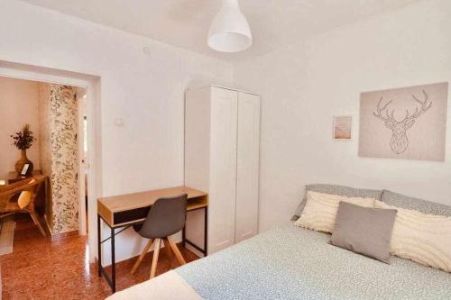 グラナダにあるFantastico apartamento en Granadaのベッドと机とテーブルのある寝室