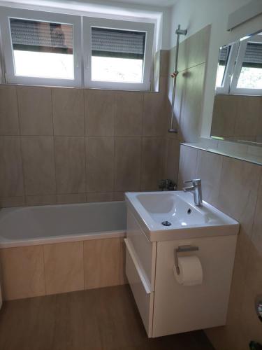 a bathroom with a white sink and a bath tub at Ferienwohnung in Hitzacker in Hitzacker