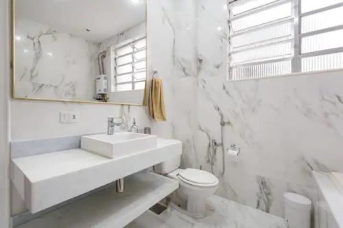 a white bathroom with a sink and a toilet at Apartamento Epitácio Pessoa in Rio de Janeiro