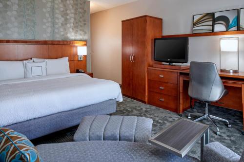 a hotel room with a bed and a desk with a television at Sonesta Select Minneapolis Eden Prairie in Eden Prairie