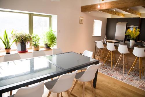 a dining room with a glass table and white chairs at Gites de l'alouette in Boffres