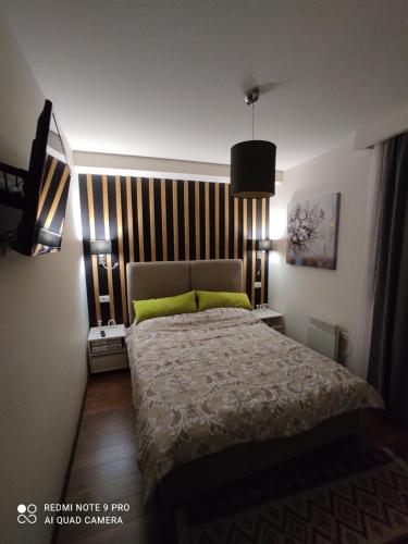 a bedroom with a bed with two yellow pillows at Apartman KulTurista in Zlatibor