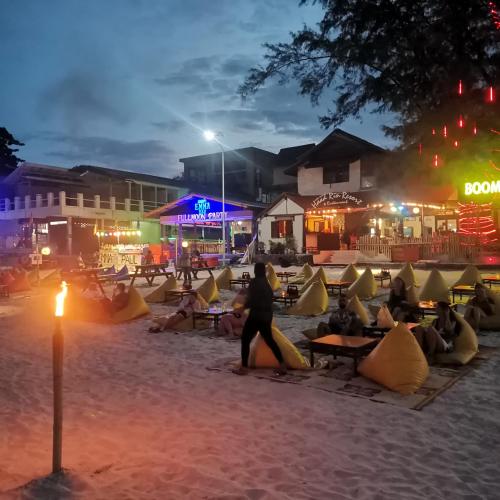 a group of people sitting on the beach at night at Haadrin village Fullmoon in Haad Rin