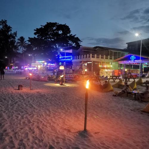 a beach at night with a light in the sand at Haadrin village Fullmoon in Haad Rin