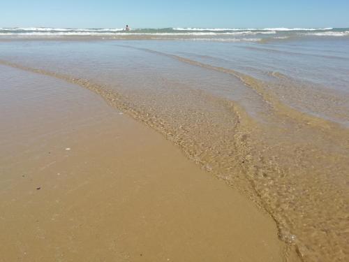 a beach with waves coming in from the ocean at B&B L'Altare Bianco in Vieste