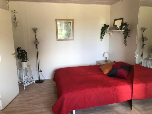 a bedroom with a red bed in a room at Kærly in Ringe