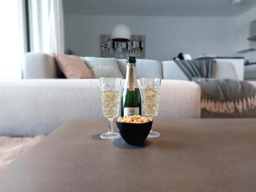 een fles champagne en twee glazen op een tafel bij Duplex Villa Capricia appartement met zwembad Nieuwpoort Jachthaven in Nieuwpoort